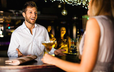 Woman talking to bartender at bar