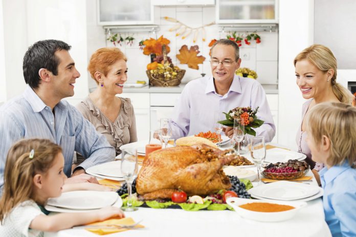 Family at the dinner table at the Thanksgiving day.