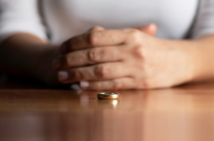 Hands of a woman who has her wedding ring taken off