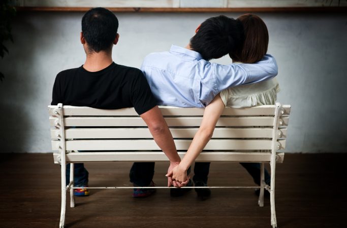 Young woman and man holding their hands behind the seat