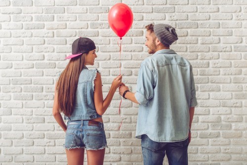 lovely couple holding a red color balloon in hands