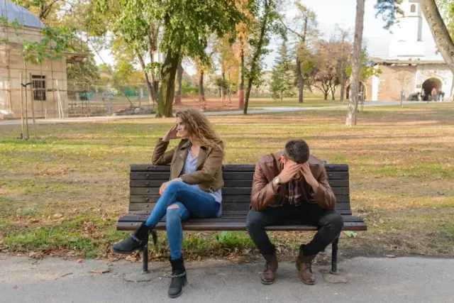 sad couple sitting on a banch