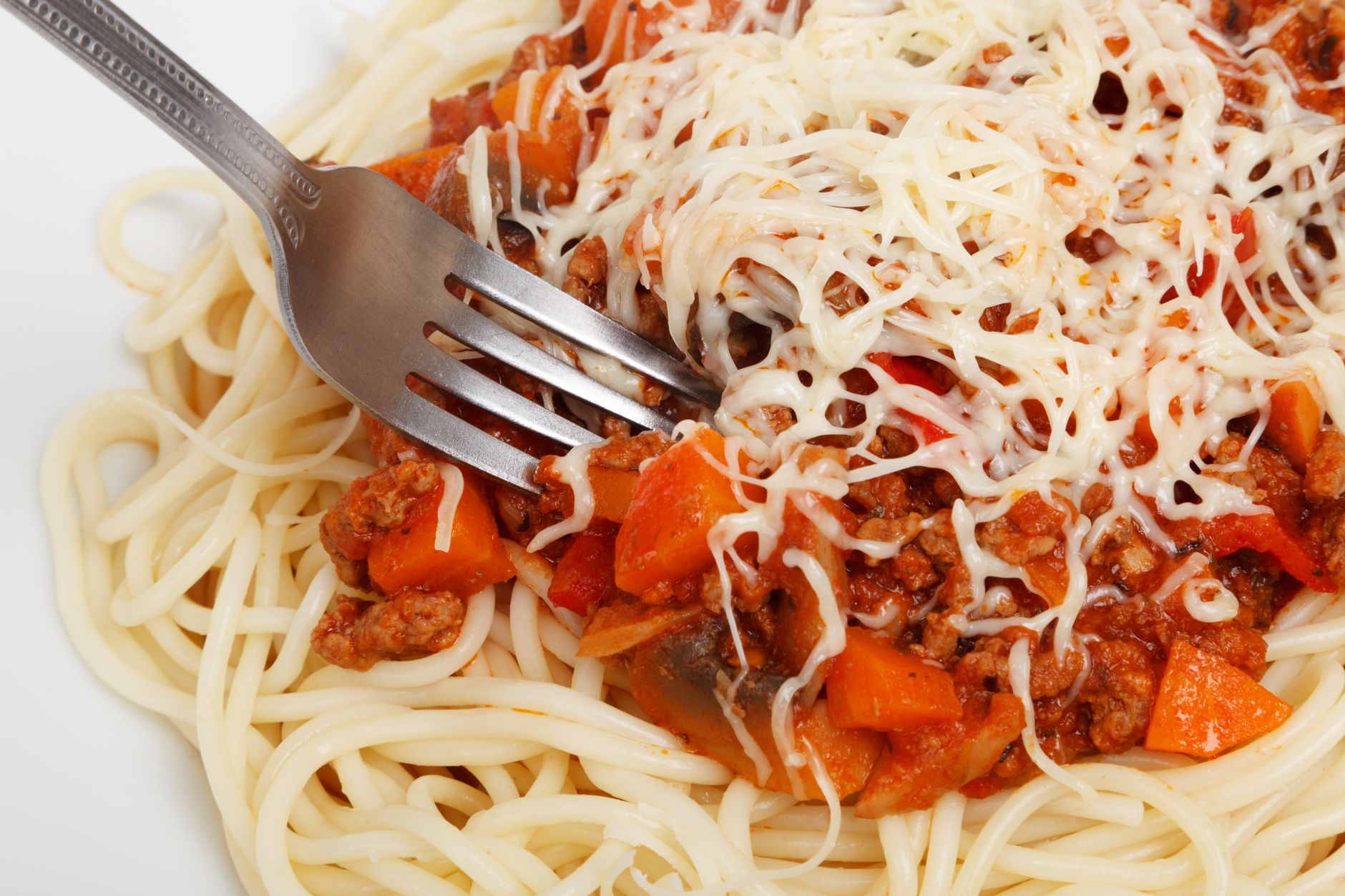Close-up of delicious spaghetti topped with bolognese sauce and cheese.