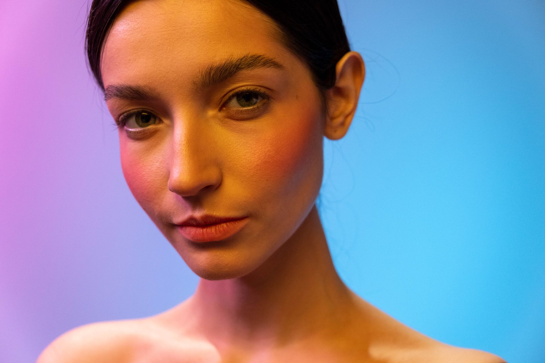 A woman in a studio with captivating neon lighting, showcasing beauty and elegance.