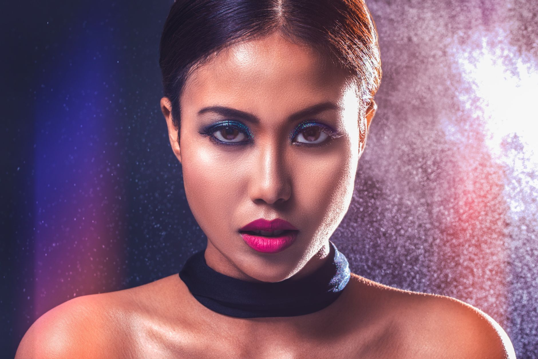 Captivating portrait of a woman with striking makeup and bold lighting.
