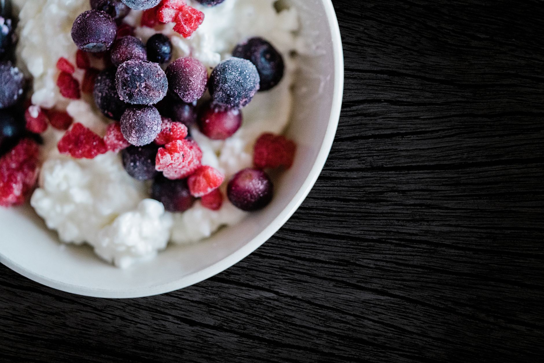 Delicious frozen berries atop creamy cottage cheese, perfect for a refreshing breakfast.