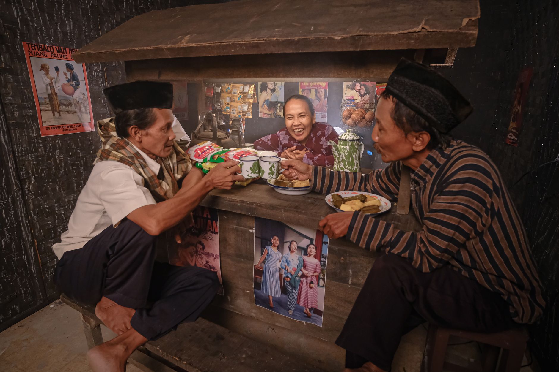 Authentic scene of adults enjoying drinks and conversation in a rustic Indonesian coffee shop.