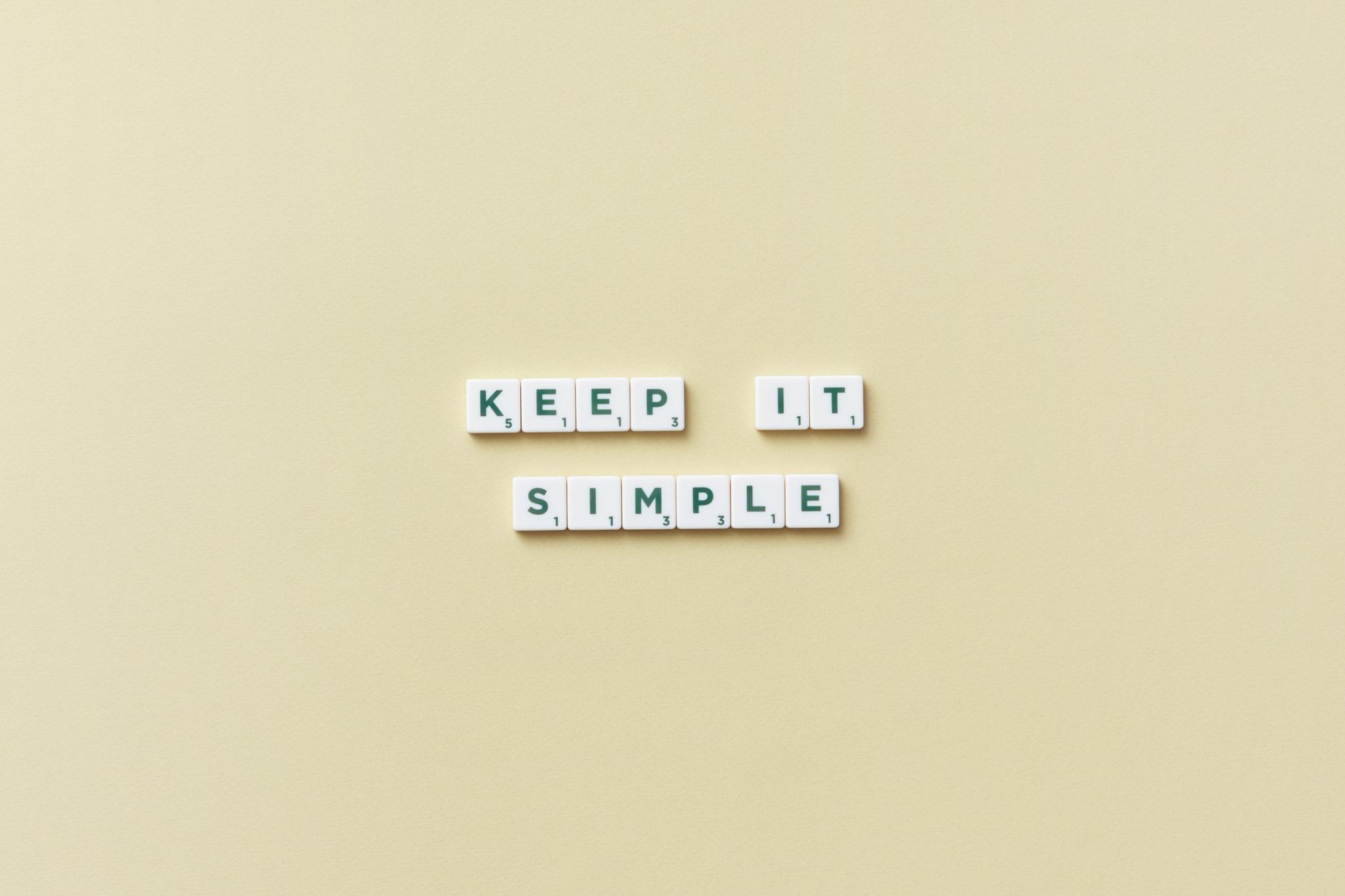 Simple message with Scrabble tiles on a pastel background promoting minimalism.
