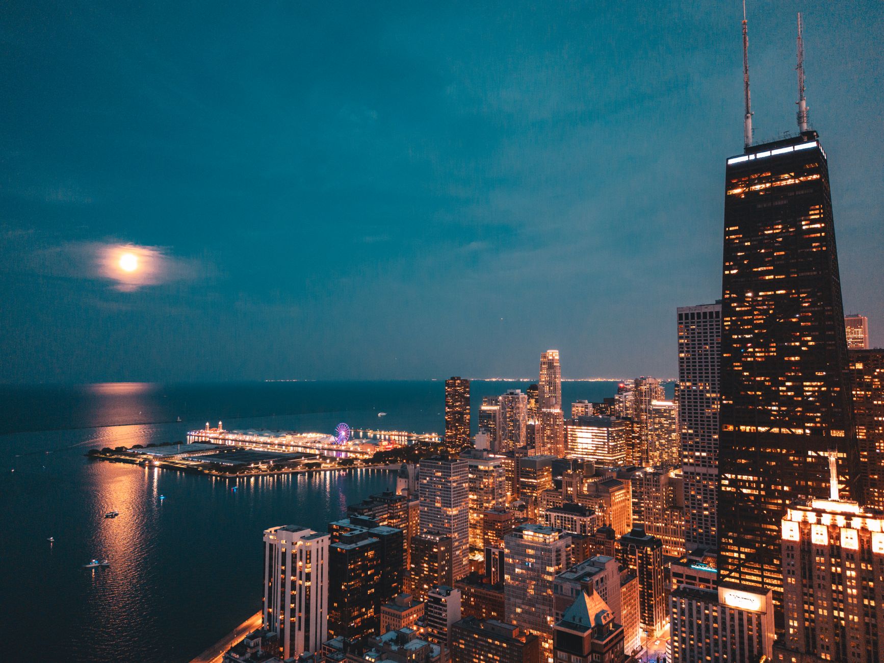Stunning aerial view of Chicago skyline under a full moon with lakefront lights.