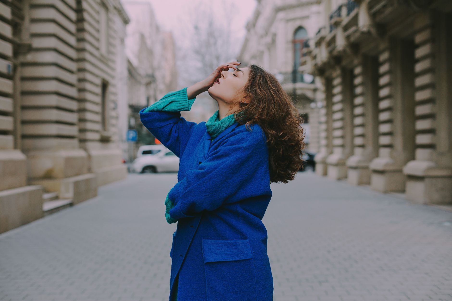 Woman in a blue coat posing confidently on an urban street in Agjabadi.