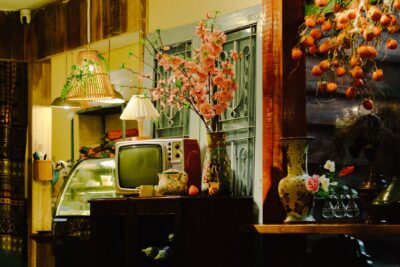Cozy interior featuring a retro TV, cherry blossoms, and warm lighting.