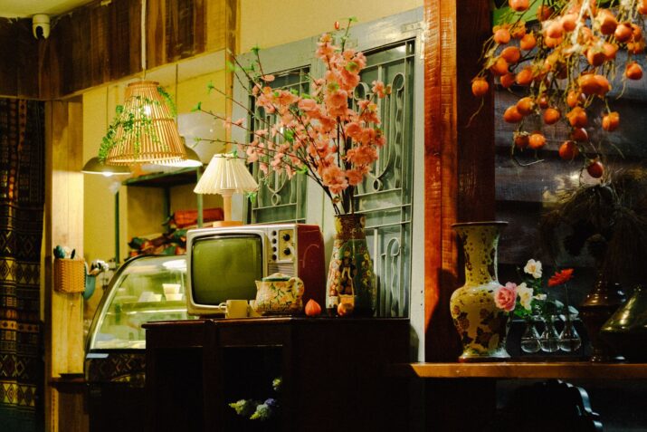 Cozy interior featuring a retro TV, cherry blossoms, and warm lighting.
