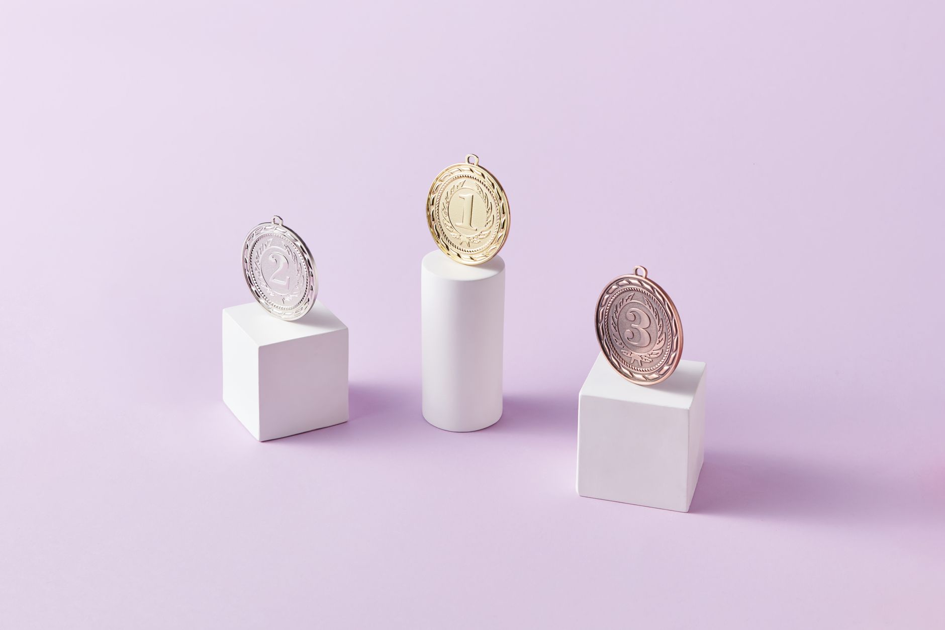 Three medals on podium blocks symbolizing first, second, and third place awards.