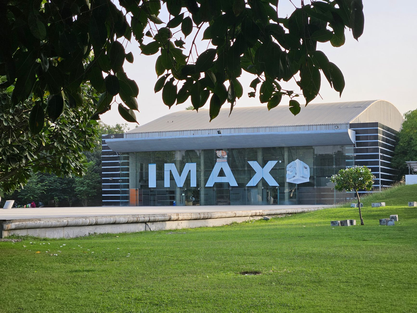 Explore the iconic IMAX theater amidst lush greenery in Ahmedabad, India.