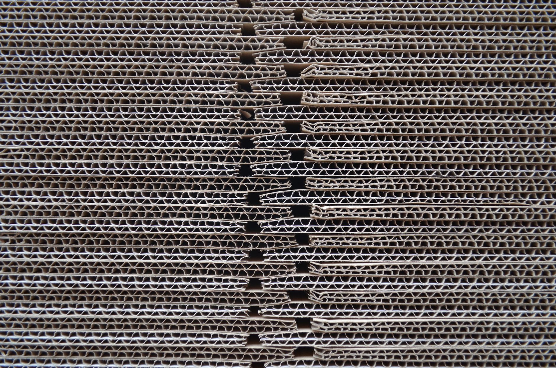 Detailed close-up of corrugated cardboard stack showcasing its wavy texture and pattern.