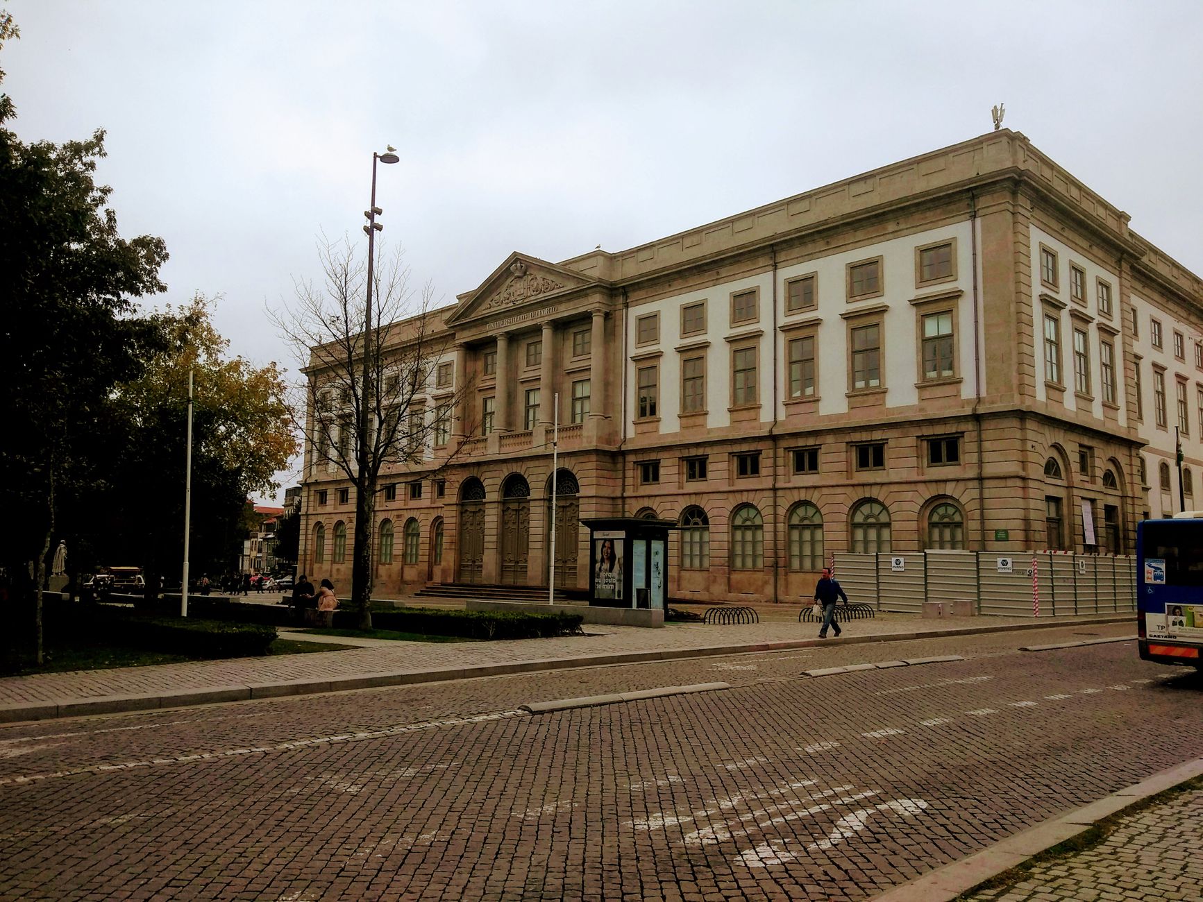A grand historic building in a European city during a cloudy day, capturing urban life.
