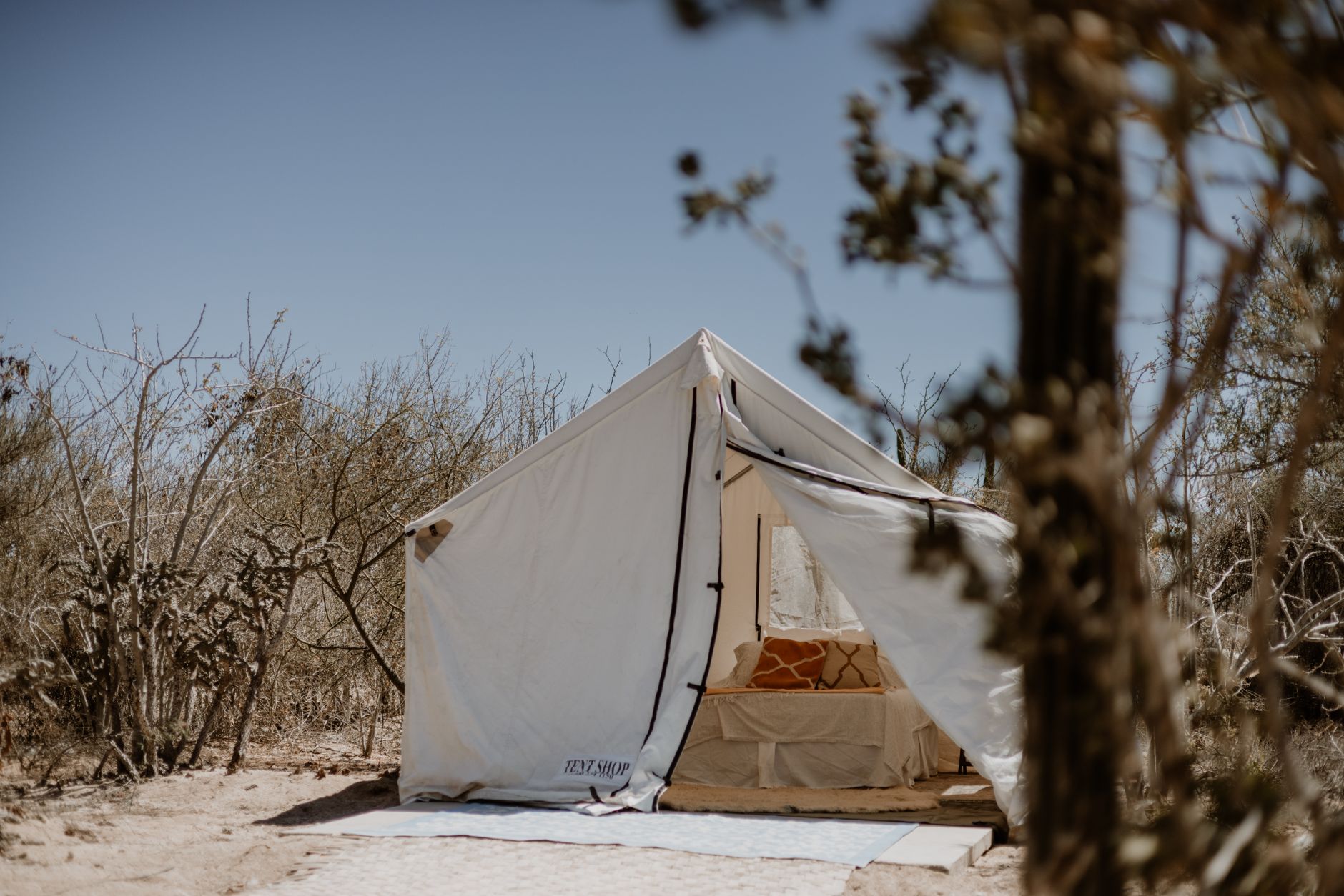 A serene glamping tent setup in a dry desert environment, ideal for adventure travelers.