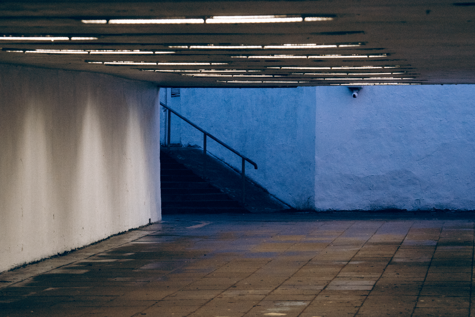 Dramatic view of an empty underground passage with stairs leading to the outside.