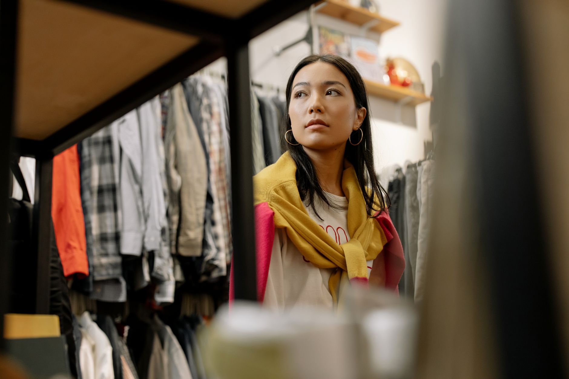 Young woman exploring trendy fashion at a thrift store, embracing vintage style.