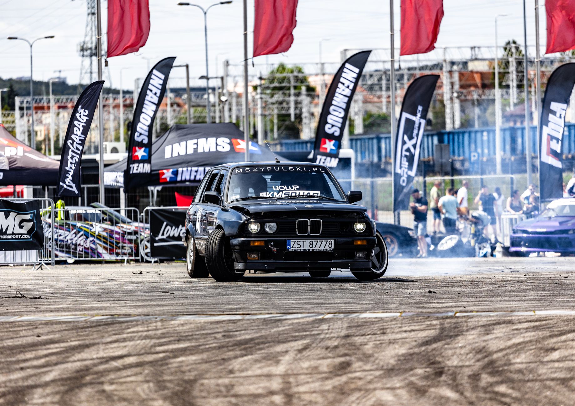 Exciting drift racing scene featuring a dynamic sports car in an urban setting during a competition.