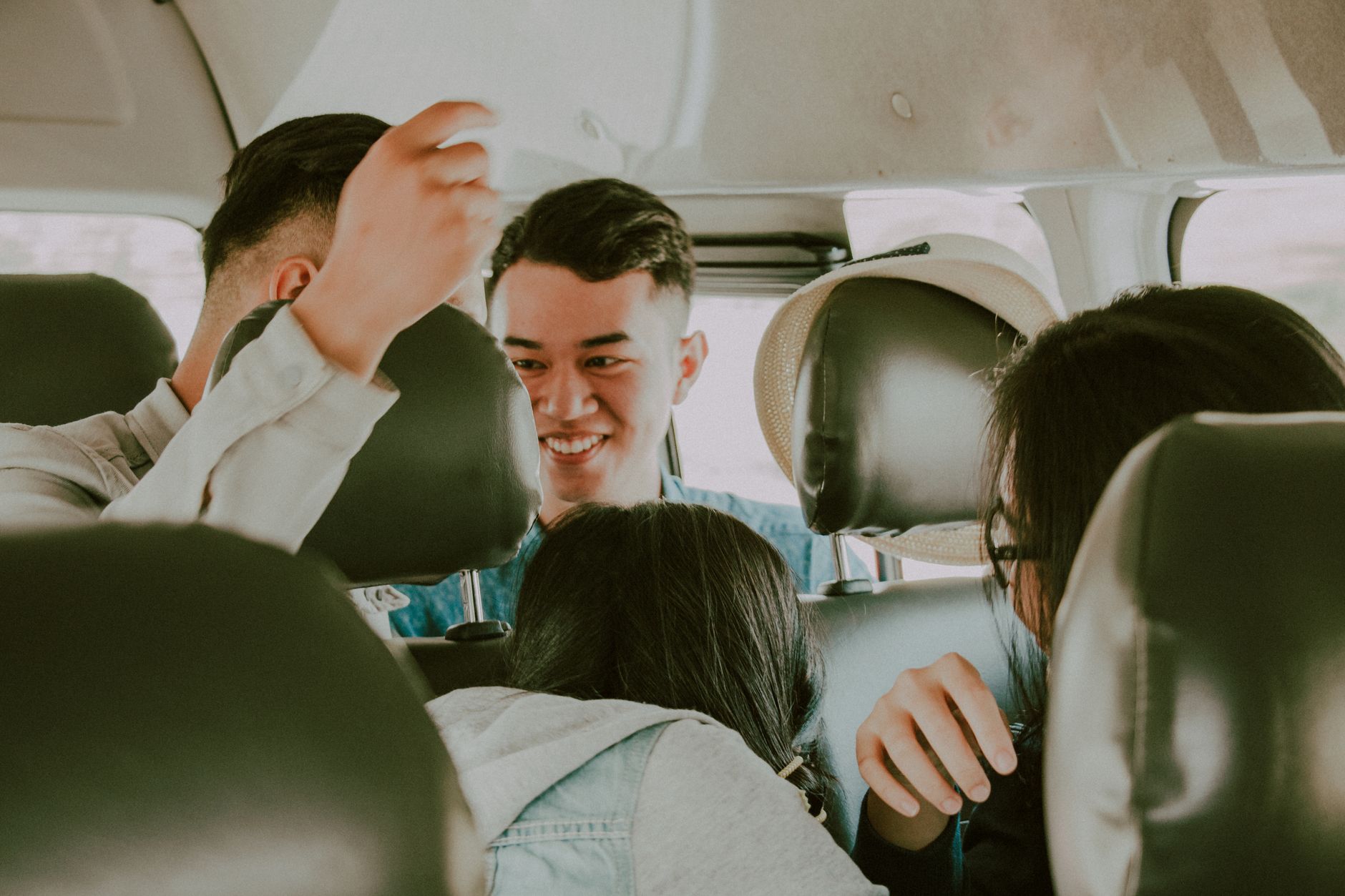Group of young friends having a fun car ride, laughing and enjoying travel moments.