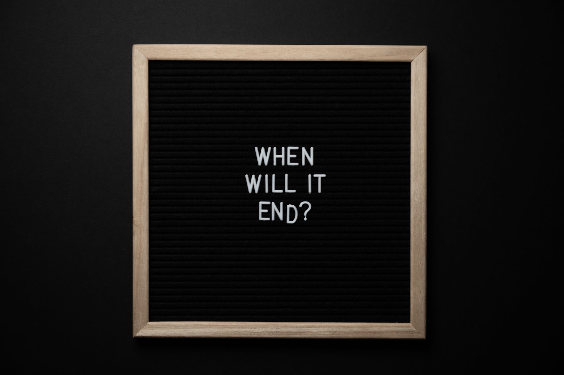 From above of chalkboard with When Will It End inscription on black background