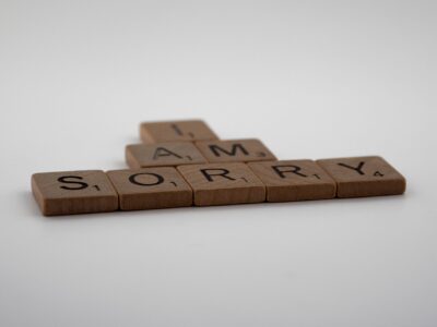 Scrabble tiles on white background forming the words 'I Am Sorry.' Ideal for conveying apologies or communication concepts.