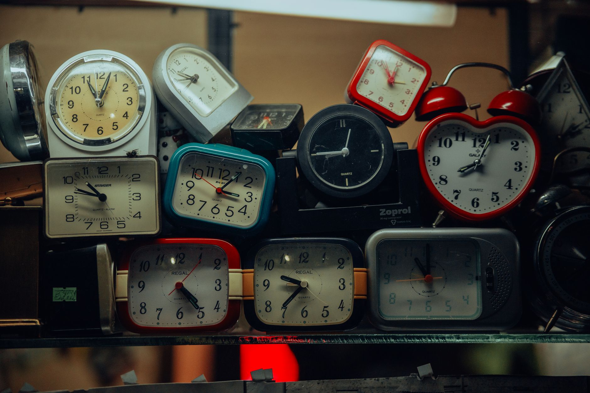 A collection of vintage alarm clocks stacked together, showcasing diverse designs and styles.