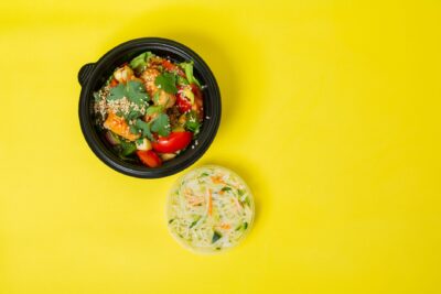 Colorful vegetable salad in a bowl with a yellow background for healthy eating concepts.